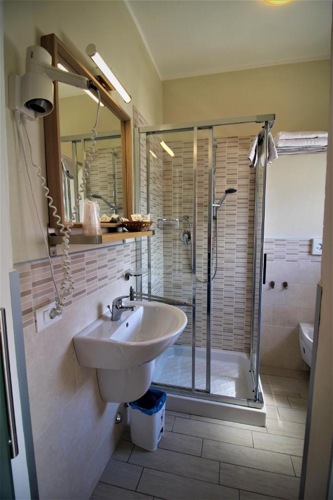 une salle de bain avec un lavabo et une douche dans l'établissement Hotel Firenze, à Caorle