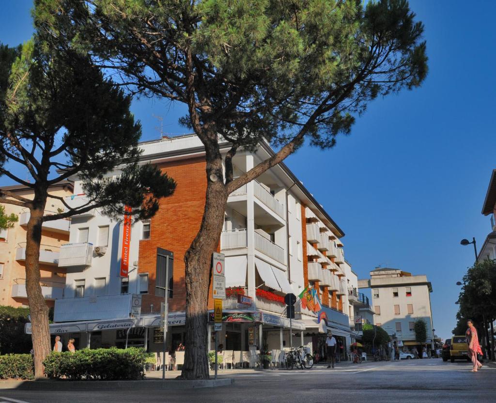 un bâtiment sur le côté d'une rue arborée dans l'établissement Hotel Firenze, à Caorle