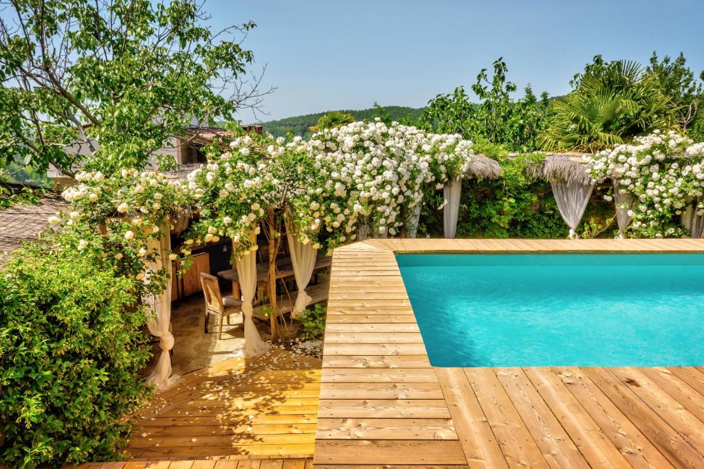 un jardin avec une piscine et une pergola dans l'établissement Borgo Marcena, à Arezzo