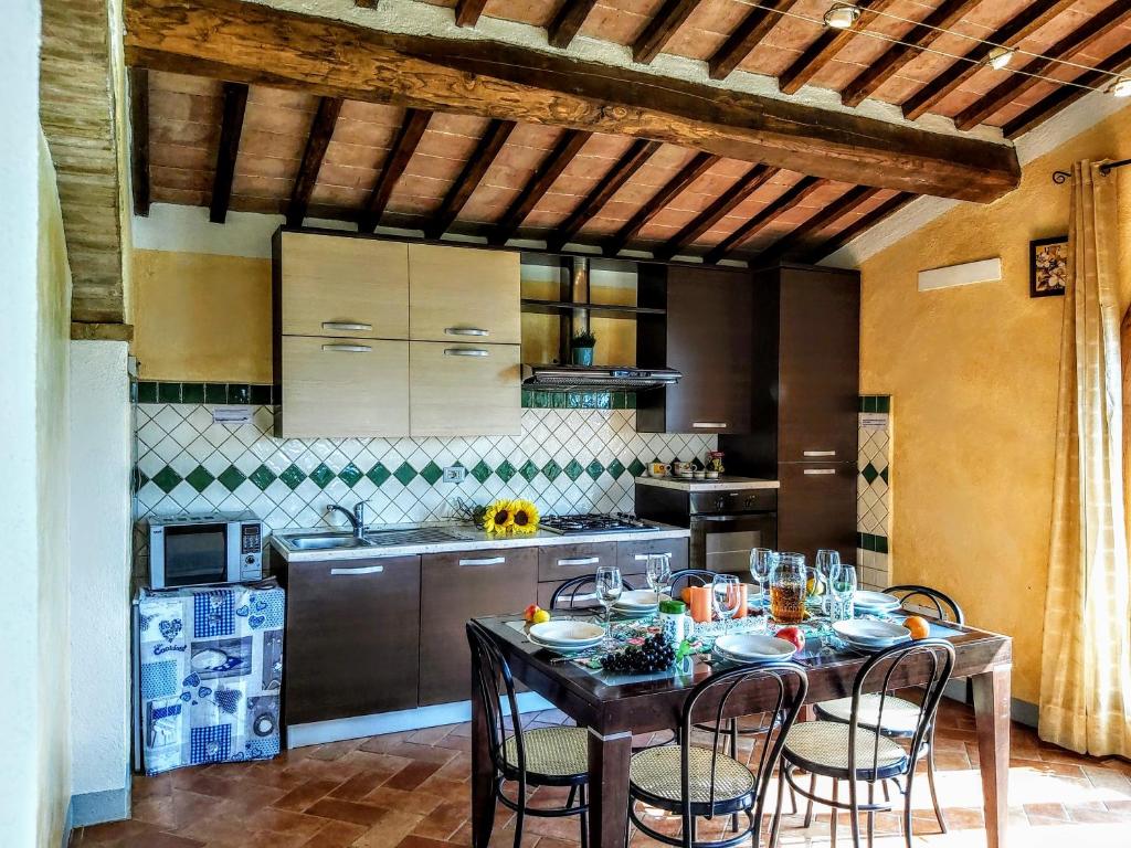 une cuisine avec une table et des chaises dans une cuisine dans l'établissement Villa S.Anna, à Montisi