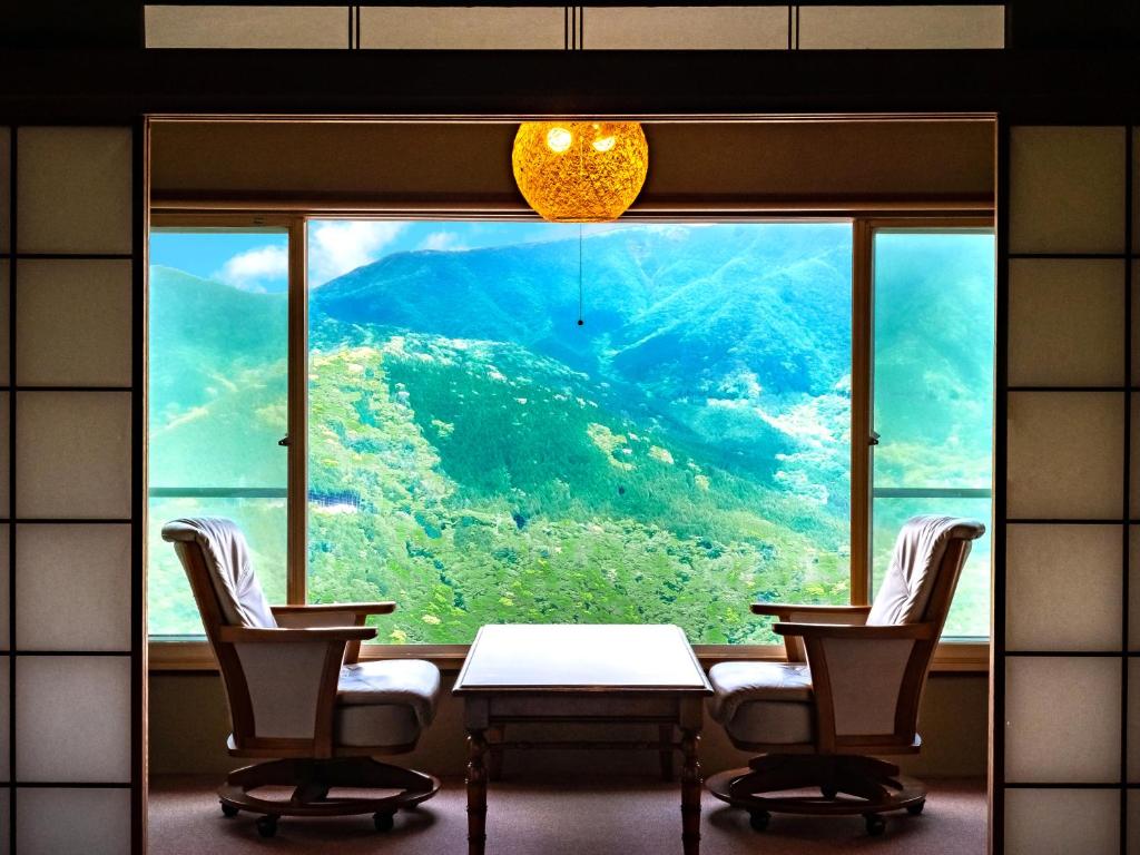 une pièce avec une table et des chaises et une grande fenêtre dans l'établissement Shirayunoyado Yamadaya Hakone Gora, à Hakone