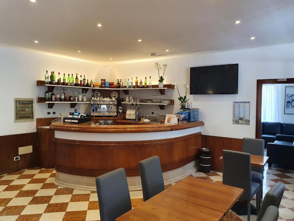 un bar dans un restaurant avec des tables et des chaises dans l'établissement Hotel Sole, à Eraclea Mare
