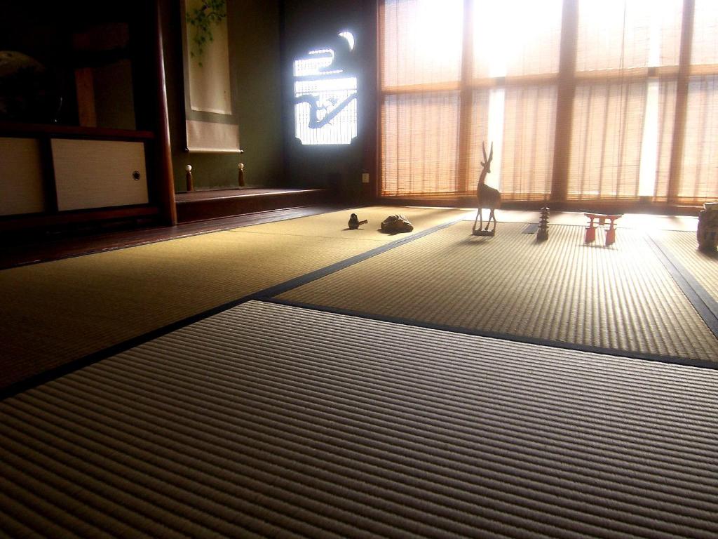 - un salon avec une grande fenêtre et 2 chats au sol dans l'établissement Itsumoya, à Miyajima 24 autres photos