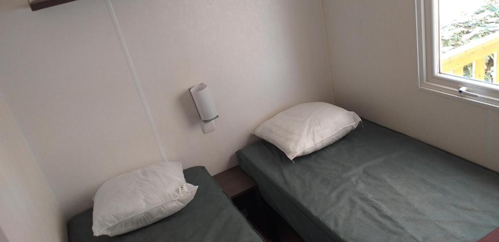 une petite chambre avec deux lits et une fenêtre dans l'établissement mobil-home camping 4 ****, à Vic-la-Gardiole 22 autres photos