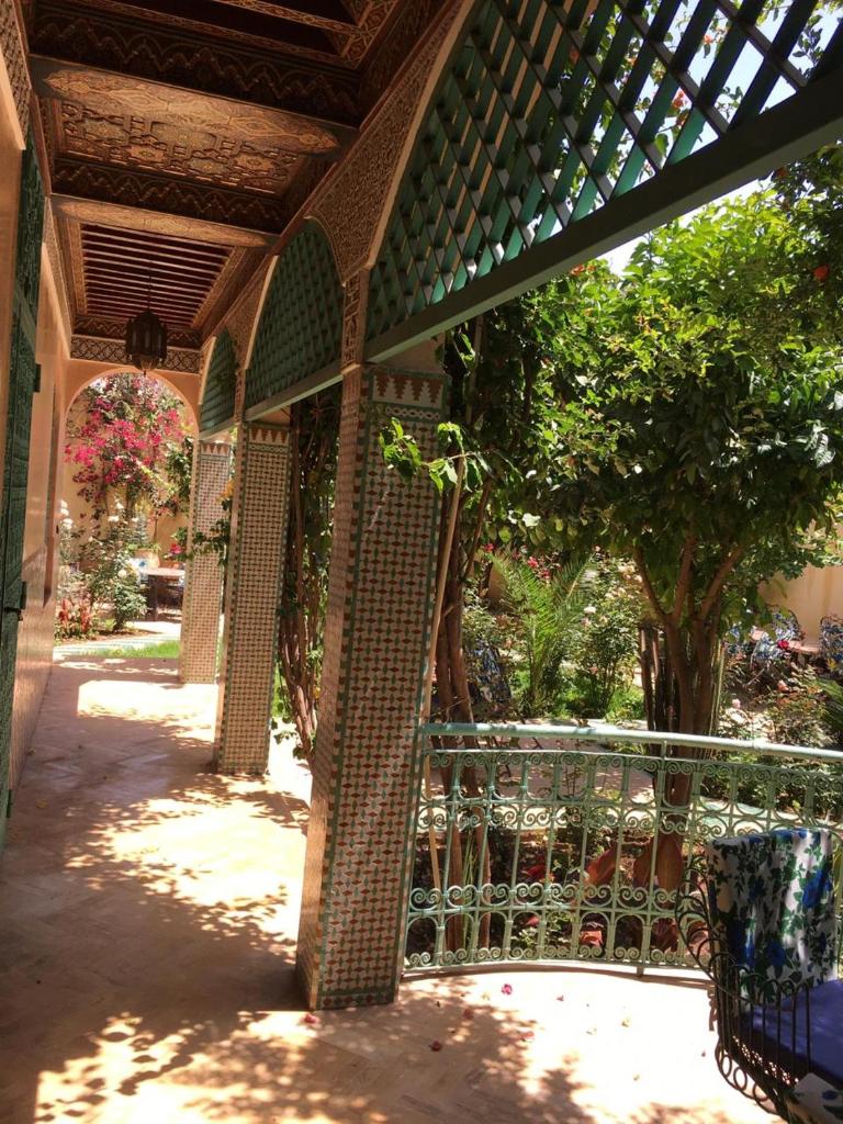 un bâtiment avec une clôture et des arbres dans une cour dans l'établissement Riad Dar Ziryab, à Fès