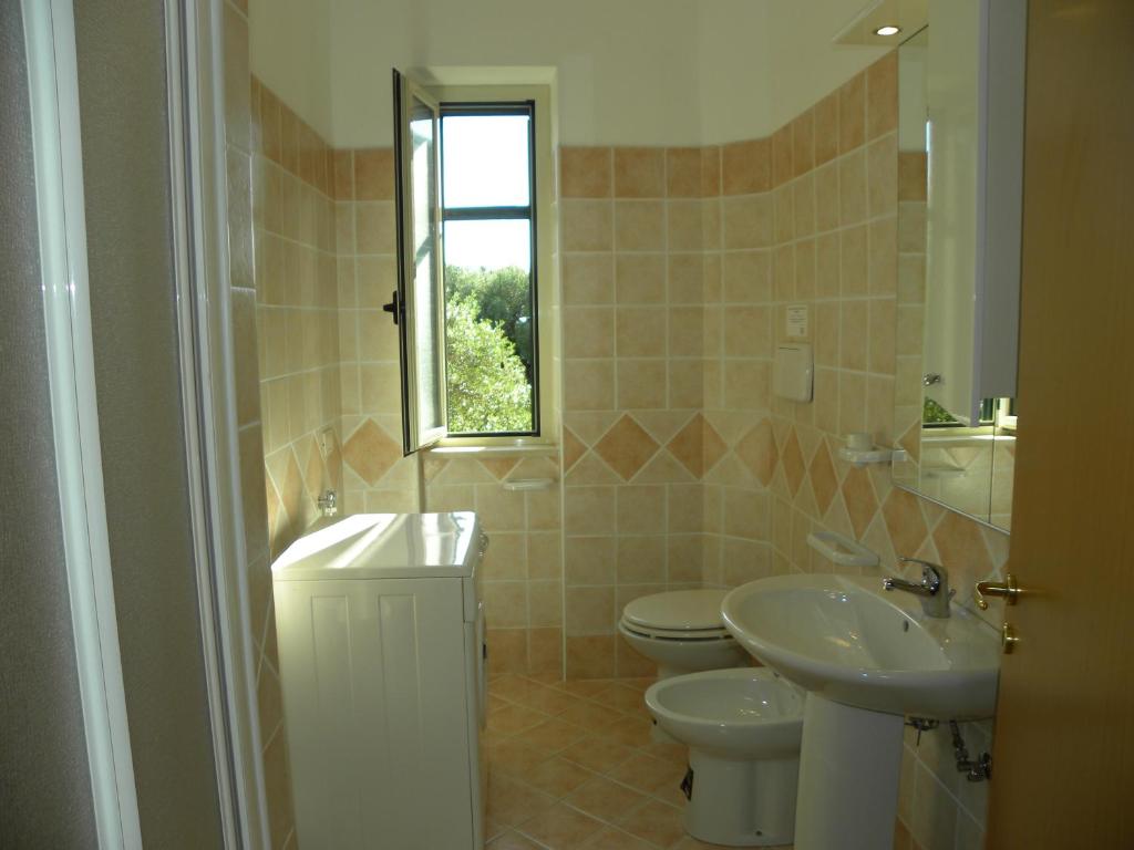 une salle de bain avec un lavabo et des toilettes et une fenêtre dans l'établissement Seamoon Residence, à Marina di Camerota 11 autres photos