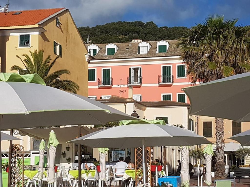 un groupe de tables et de parasols devant un bâtiment dans l'établissement Hotel Splendid Mare, à Laigueglia