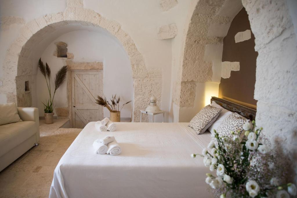 une chambre avec un lit blanc avec des serviettes dessus dans l'établissement Dimora Millepietre, à Alberobello