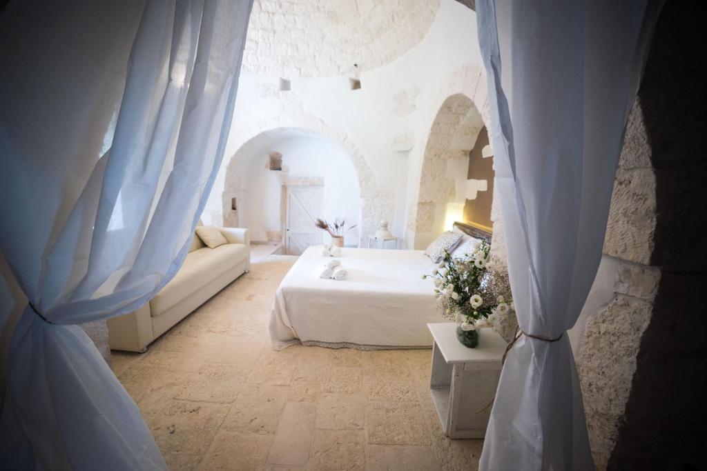 - une chambre avec un lit doté de rideaux bleus dans l'établissement Dimora Millepietre, à Alberobello 42 autres photos