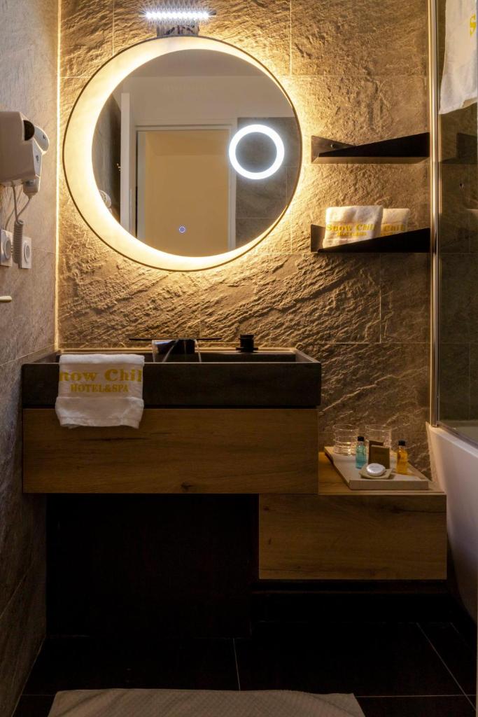 une salle de bain avec un lavabo et un miroir dans l'établissement Hotel SNOW CHILL, à Risoul