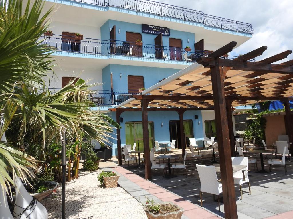 une terrasse d'un hôtel avec des tables et des chaises dans l'établissement ChrisMare Hotel, à Mazzeo