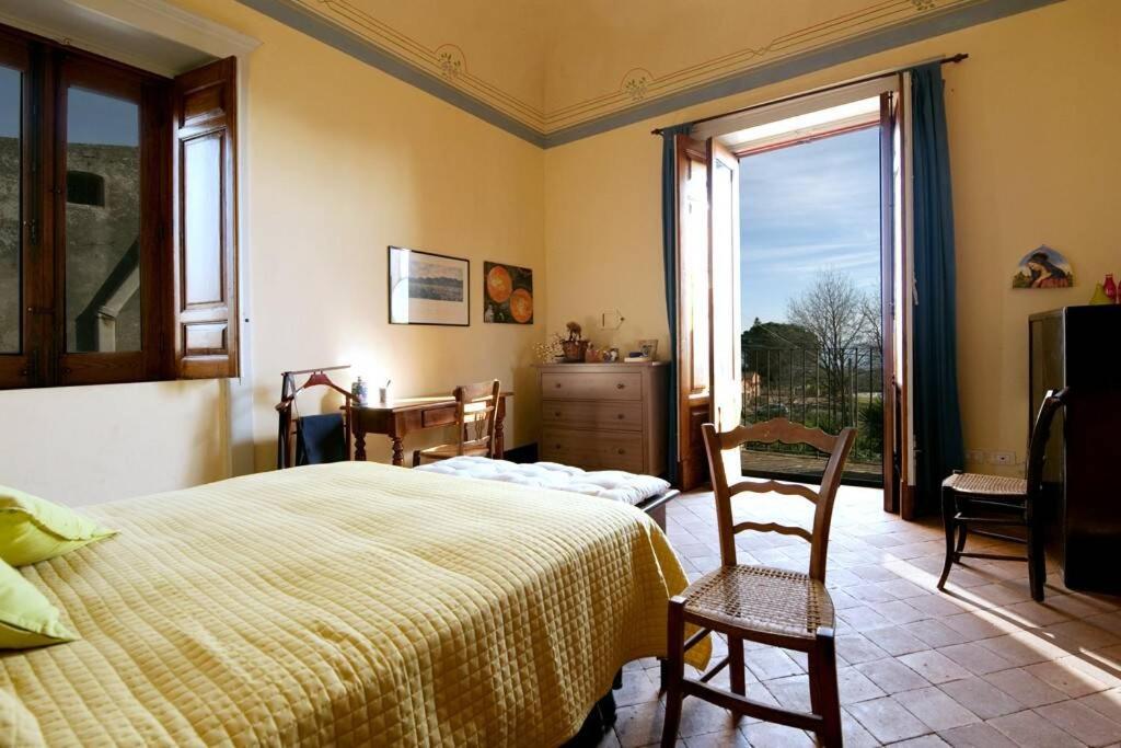 une chambre avec un lit, des chaises et une fenêtre dans l'établissement villa dei limoni, à San Leonardello