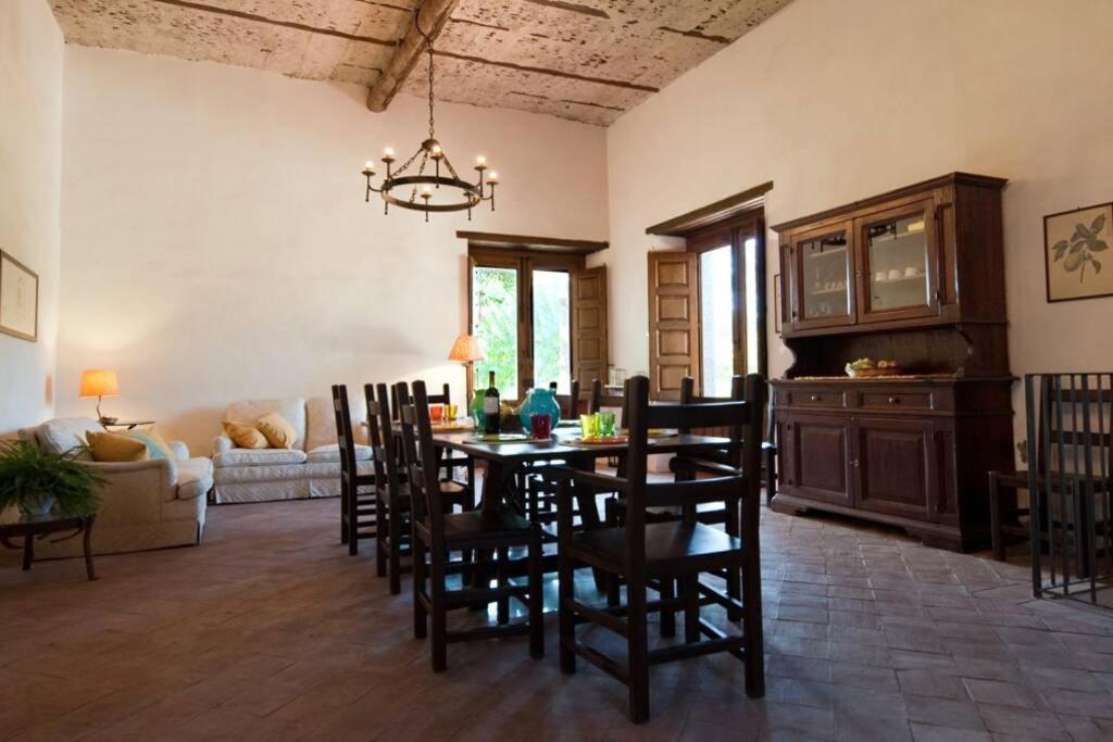 une salle à manger et un salon avec une table et des chaises dans l'établissement villa dei limoni, à San Leonardello