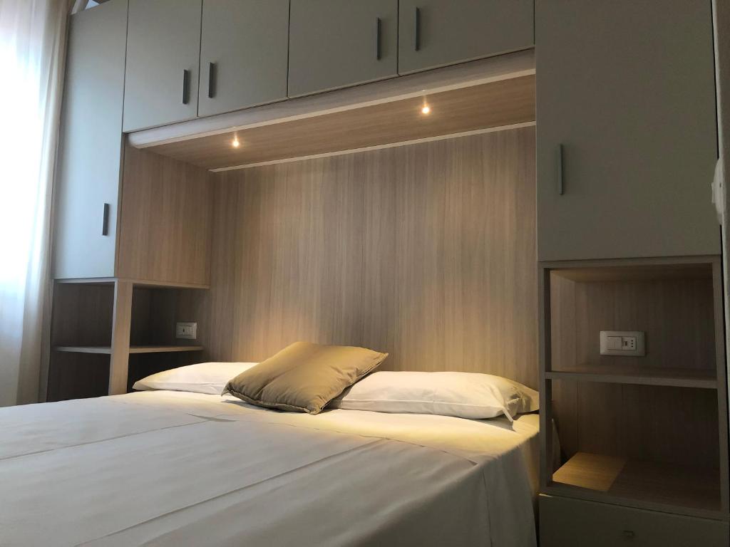 une chambre avec un grand lit avec des draps blancs dans l'établissement Hotel Karibe, à Bibione