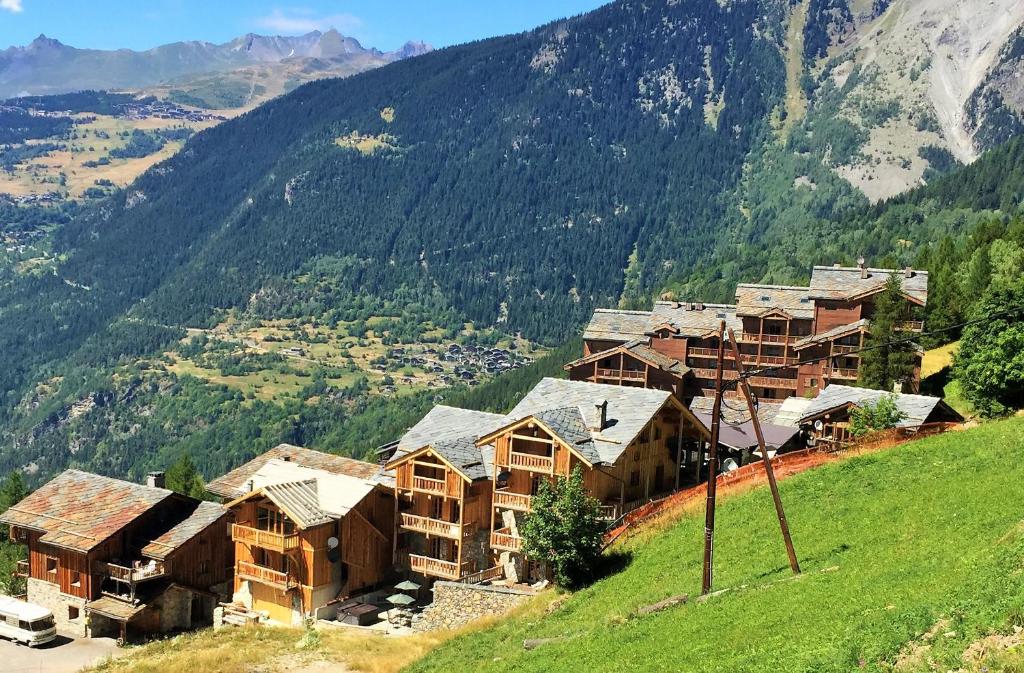un groupe de bâtiments sur une colline avec une montagne dans l'établissement Black Diamond Sainte Foy Chalets, à Sainte-Foy-Tarentaise