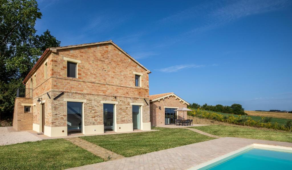 une maison en briques avec une piscine devant dans l'établissement Villa Saltregna, à Cervidone
