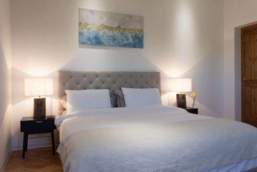 une chambre avec un grand lit blanc avec deux lampes dans l'établissement Villa Saltregna, à Cervidone 30 autres photos