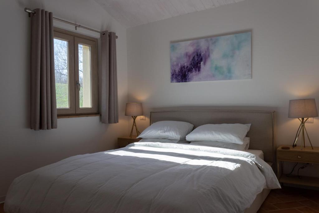 - une chambre avec un grand lit blanc et 2 fenêtres dans l'établissement Villa Saltregna, à Cervidone