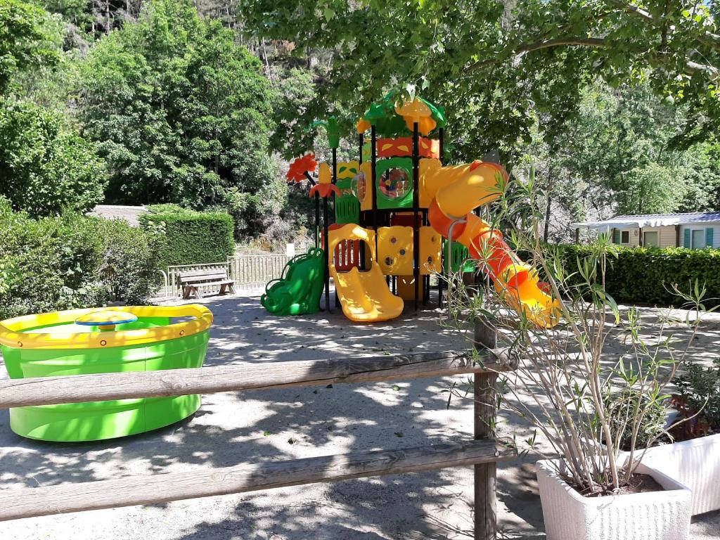un parc avec une aire de jeux et une structure de jeux dans l'établissement Camping de Retourtour, à Lamastre