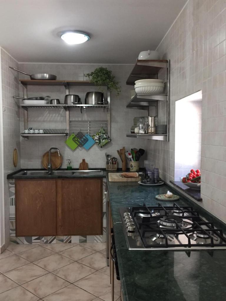 une cuisine avec une cuisinière et un comptoir dans l'établissement Villa panoramica con piscina, à Lido Marini