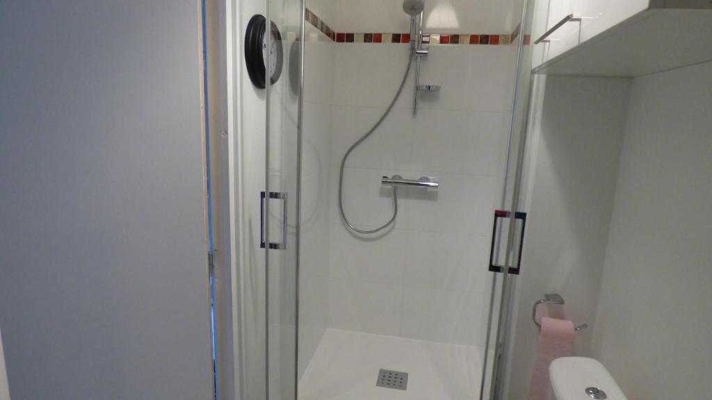 une douche avec une porte vitrée dans une salle de bain dans l'établissement La tente de la plage, à Plouha