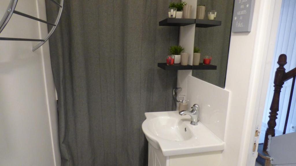 une salle de bain avec un lavabo et un rideau de douche dans l'établissement La tente de la plage, à Plouha