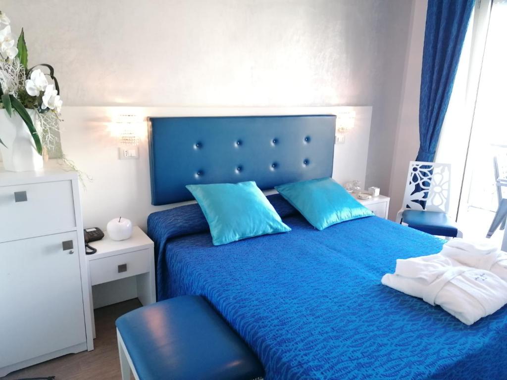 - un lit bleu avec des oreillers bleus dans une chambre dans l'établissement Hotel Nordic, à Bellaria-Igea Marina