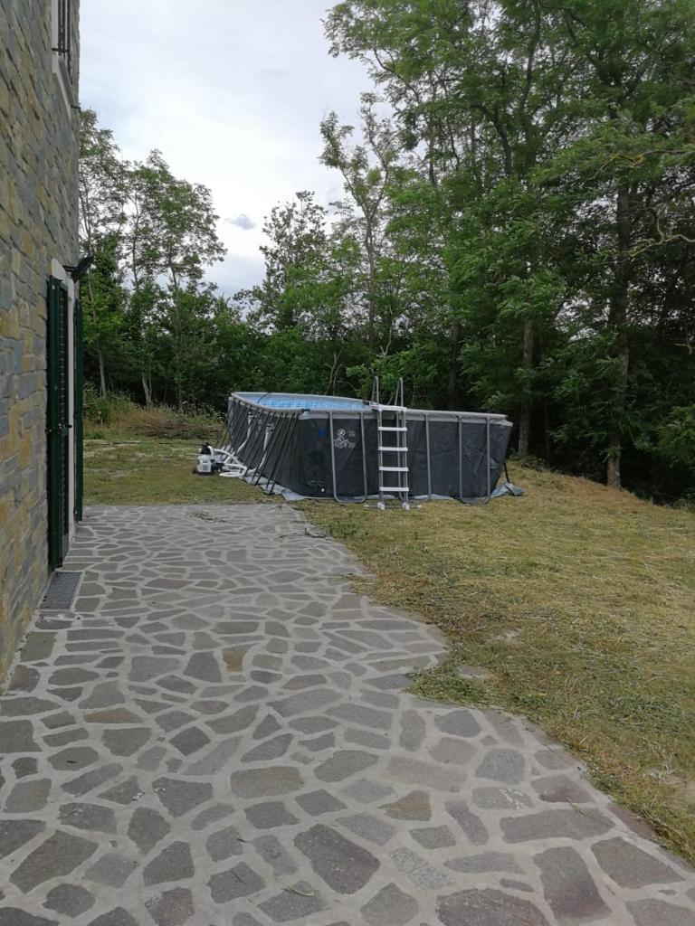 une passerelle en pierre avec une tente dans un champ dans l'établissement Villa Viktoria & Andras, à Tredozio