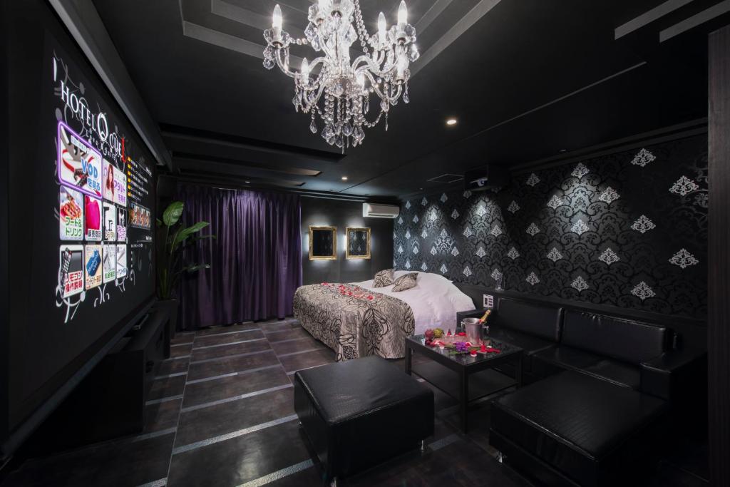 une chambre noire avec un lit et un lustre dans l'établissement Hotel Eldia Machida -Adult Only, à Kami-seya