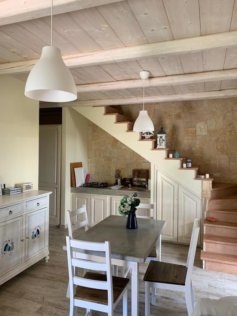 une cuisine avec une table et des chaises ainsi qu'un escalier dans l'établissement VILLA ERSILIA, à Porto Columbu - Perdʼe Sali