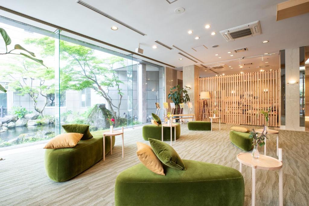 - un hall doté d'un mobilier vert et de grandes fenêtres dans l'établissement Yutoriro Bandai Atami, à Koriyama