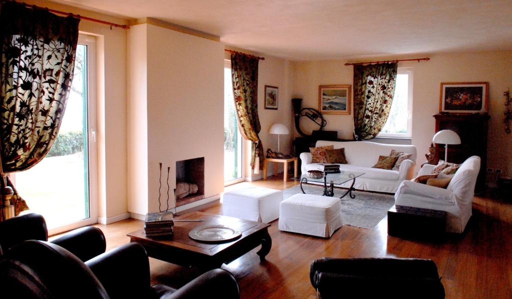 un salon avec des meubles blancs et une grande fenêtre dans l'établissement Villa Altar, à Bolano