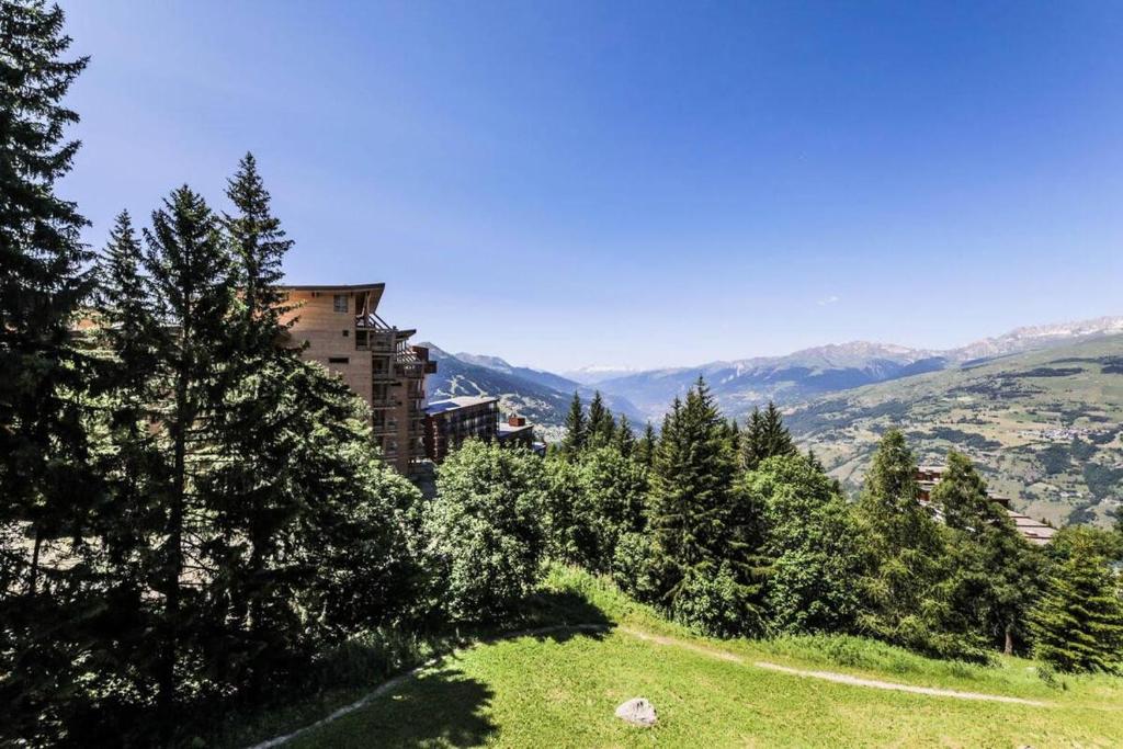 un bâtiment au sommet d'une colline avec des arbres dans l'établissement Les Arcs 1800, Nova 2, 6 pers, Parking couvert gratuit, à Arc 1800