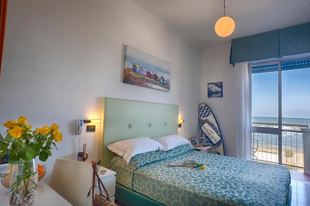 une chambre avec un lit avec vue sur l'océan dans l'établissement San Giorgio Savoia, à Bellaria-Igea Marina