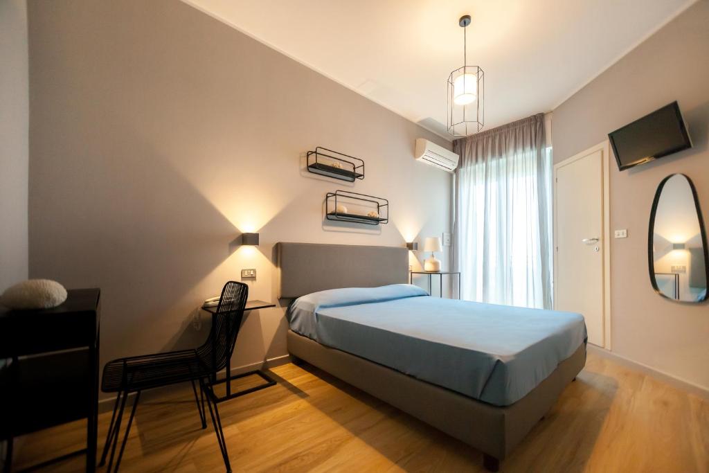 une chambre avec un lit, un bureau et une chaise dans l'établissement Hotel Brig, à Riccione