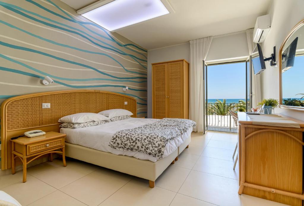 - une chambre avec un grand lit et une vue sur l'océan dans l'établissement Hotel Mandetta - Adults Only, à Paestum 107 autres photos