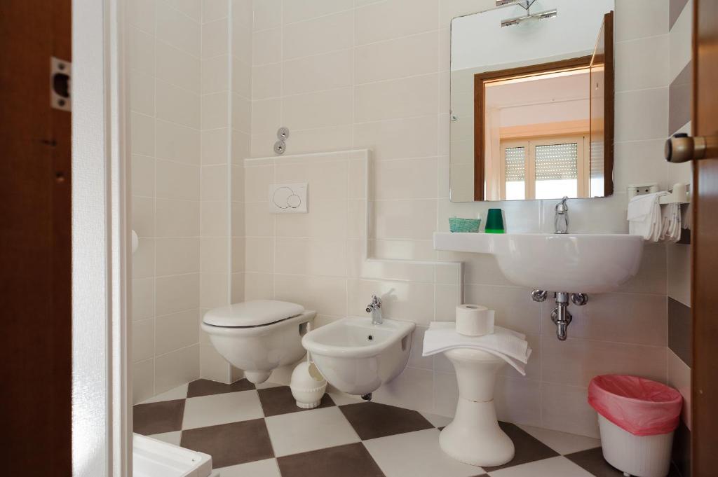 une salle de bain blanche avec un lavabo et des toilettes dans l'établissement Hotel Residence Villa Jolanda, à Lido di Camaiore