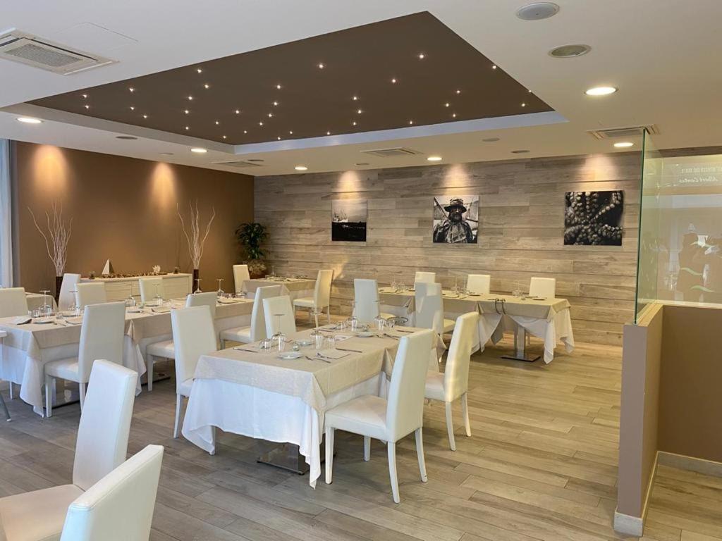 une salle à manger avec des tables blanches et des chaises blanches dans l'établissement Elite Boutique Hotel, à Roseto degli Abruzzi