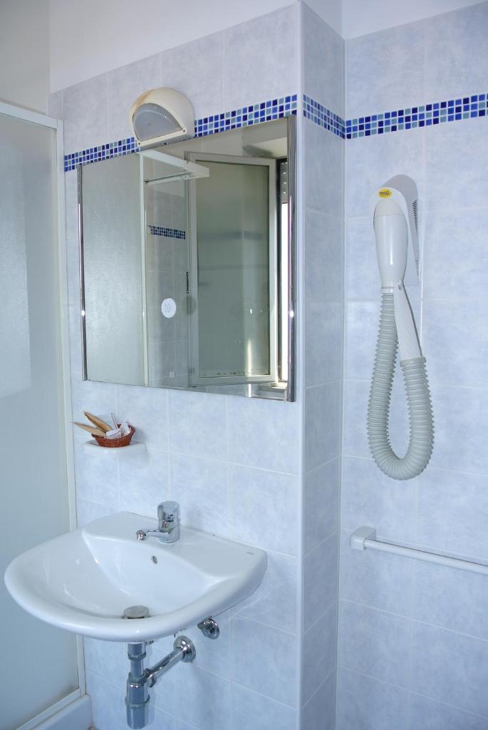 une salle de bain blanche avec un lavabo et un miroir dans l'établissement Hotel Mirage, à Lido di Classe