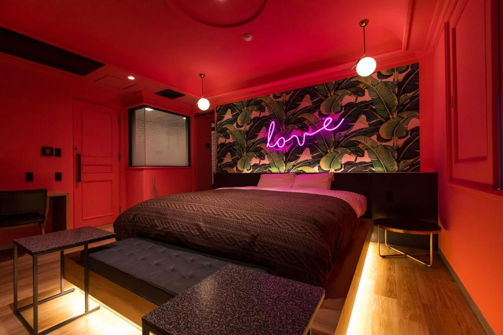- une chambre dotée d'un lit avec un panneau de néon sur le mur dans l'établissement Hotel Odo-Adult Only, à Fukuoka