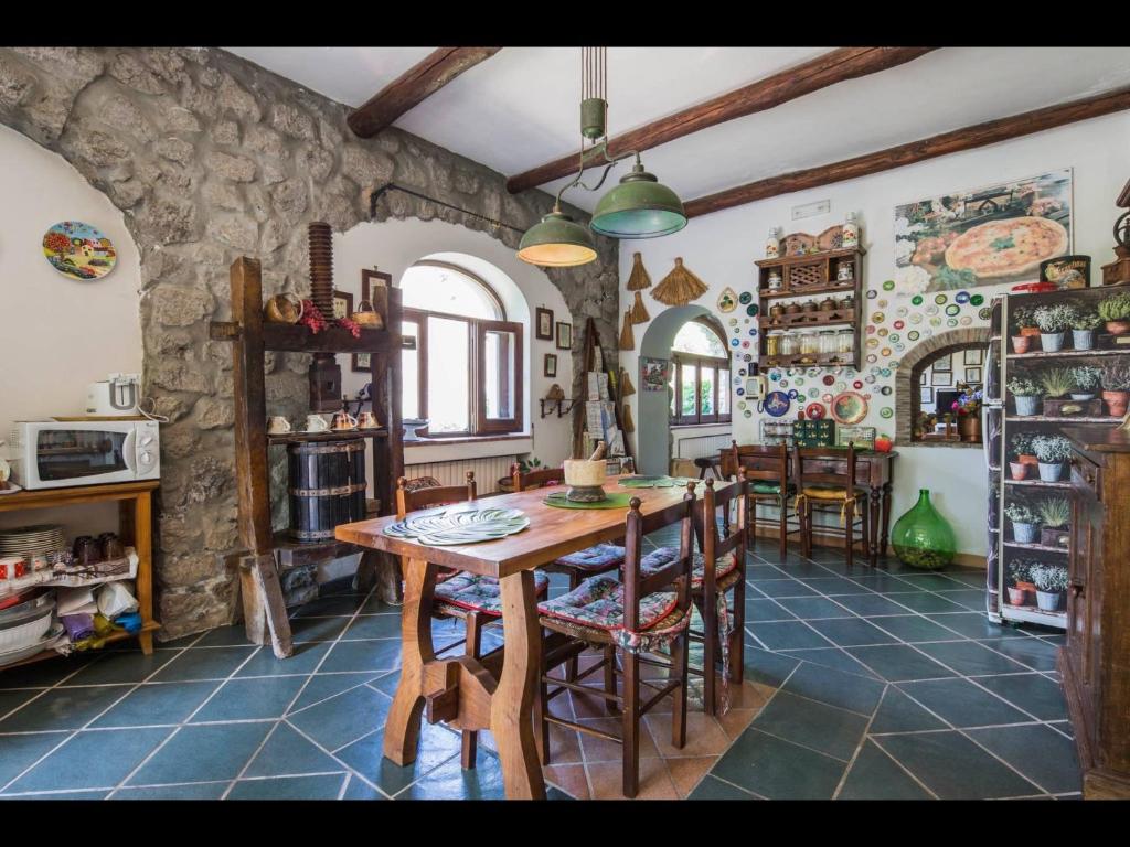 une cuisine avec une table et des chaises dans une pièce dans l'établissement Rocca Angelica, à Vico Equense