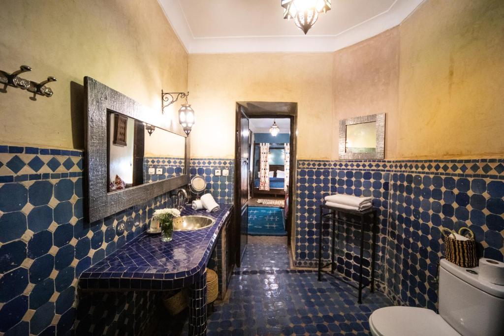 une salle de bain avec un lavabo et un miroir et des toilettes dans l'établissement Riad Mur Akush, à Marrakech 37 autres photos