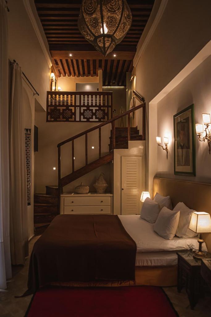 une chambre avec un grand lit et un escalier dans l'établissement Dar Shâan, à Rabat