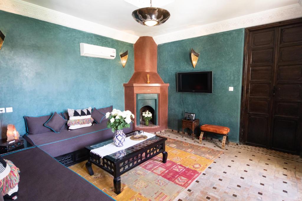 un salon avec un canapé et une cheminée dans l'établissement Riad Mur Akush, à Marrakech