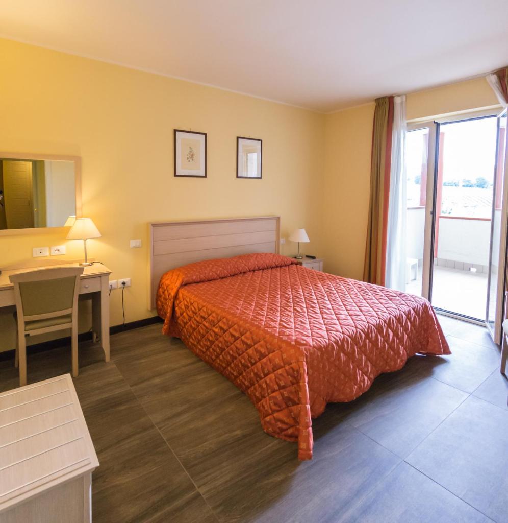 une chambre d'hôtel avec un lit, un bureau et une fenêtre dans l'établissement Il Parco Sul Mare Resort & SPA, à Tortoreto Lido