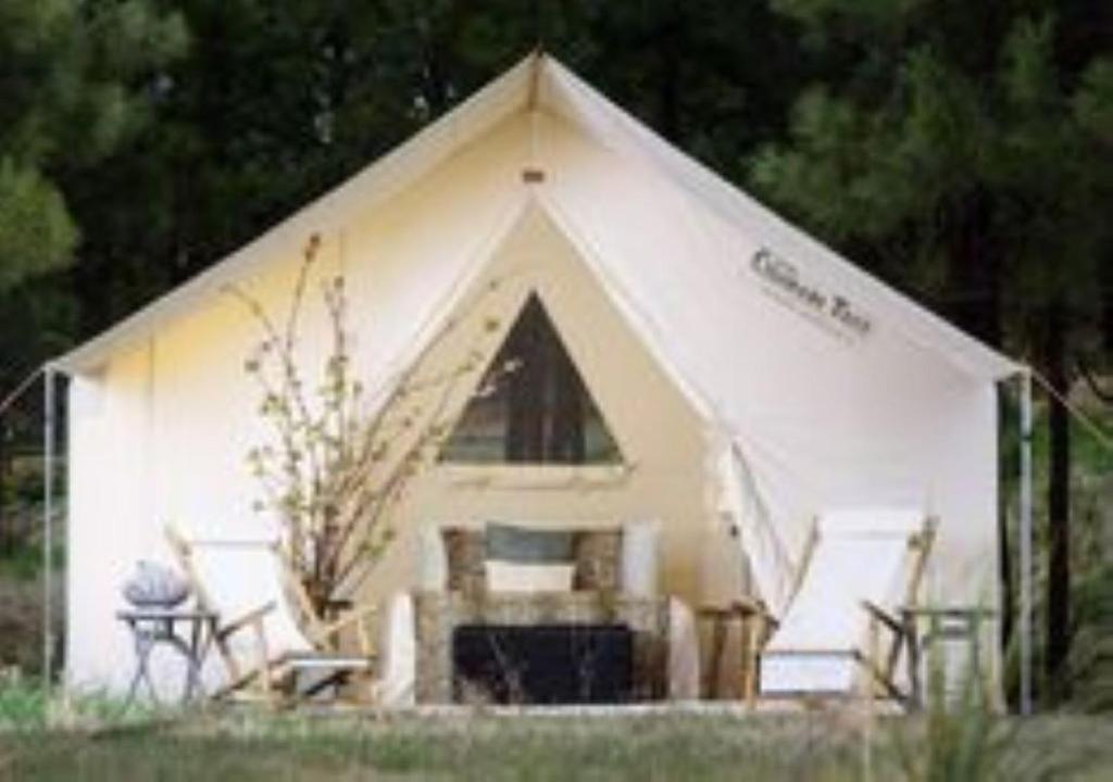 une tente blanche avec deux chaises et une table dans l'établissement French Fields Luxury Glamping Twin Emperor Tent, à Le-Vieux-Cérier