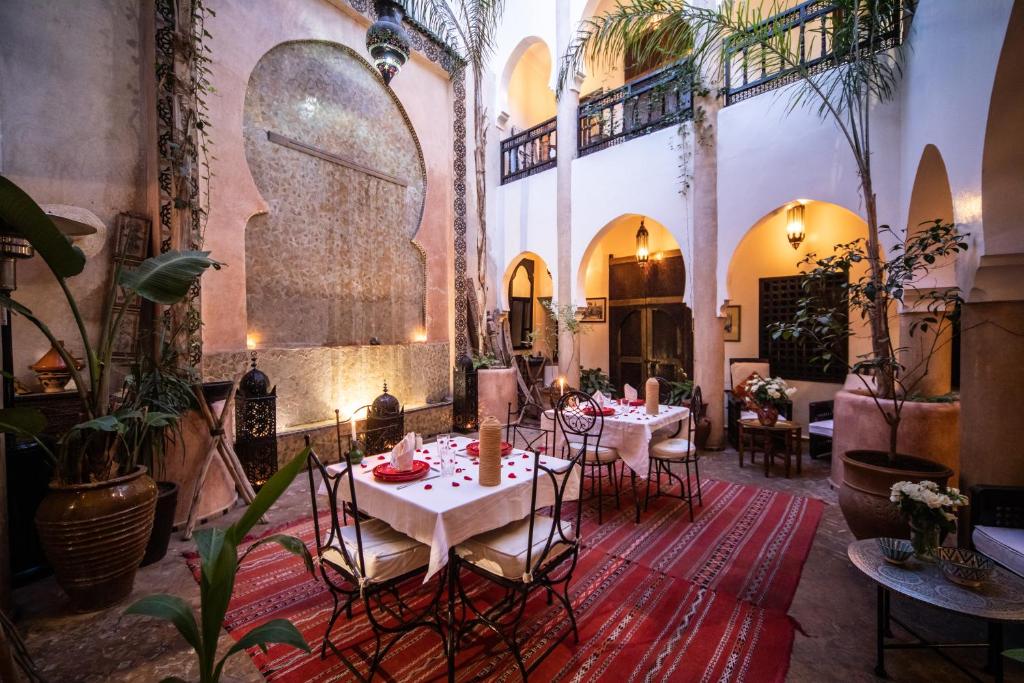 une salle à manger avec tables et chaises dans un bâtiment dans l'établissement Riad Mur Akush, à Marrakech