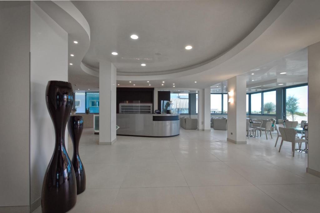 un hall avec des vases sur le mur dans un bâtiment dans l'établissement Hotel Monaco, à Caorle 163 autres photos