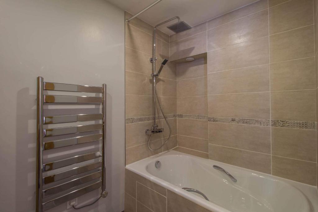 une salle de bain avec baignoire et douche dans l'établissement 30 Praz Ski-in Ski-out Vallandry - Les Arcs - Paradiski, à Peisey-Nancroix