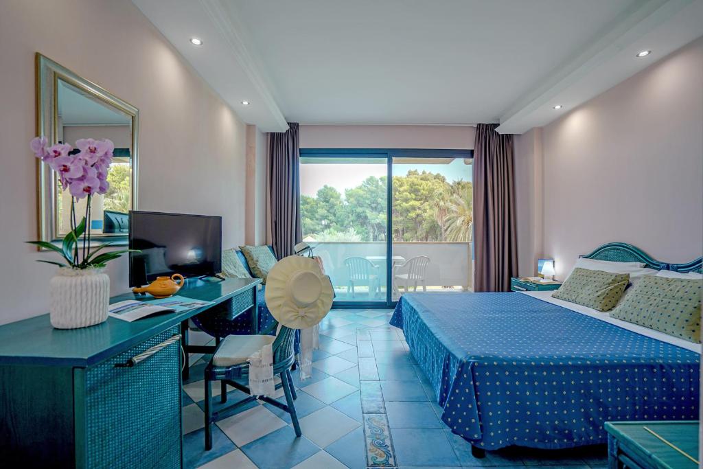 une chambre avec un lit et un bureau avec un ordinateur dans l'établissement Villaggio Giardini D'Oriente, à Nova Siri Marina